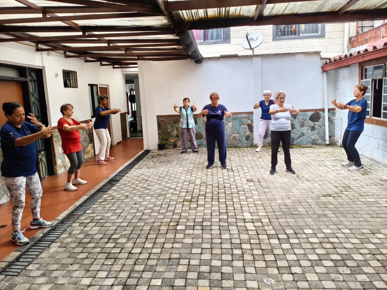 Clase de tai chi para adultos mayores en el patio de XIHU, Laureles, Medellín
