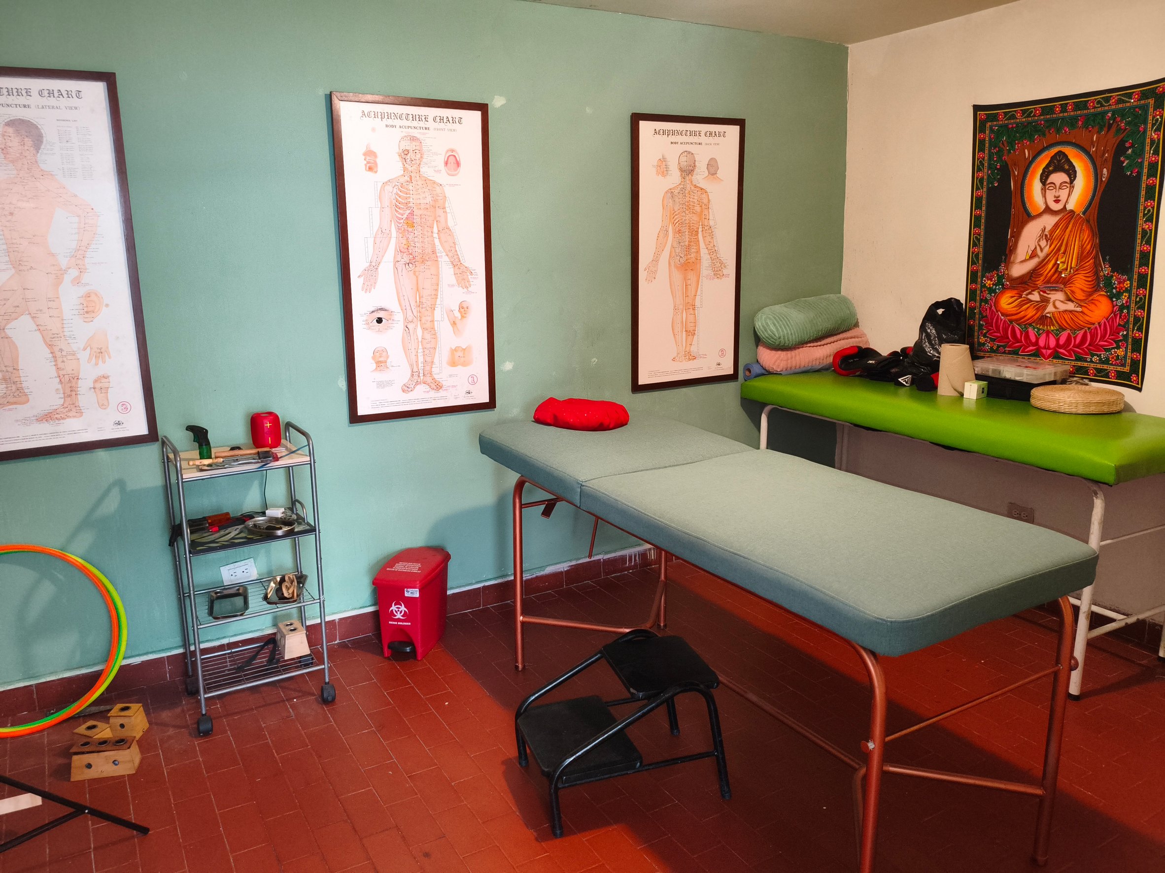 Sala de terapias de XIHU con camilla y láminas de acupuntura